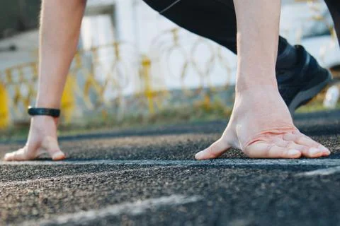 One runner on the starting line on the stadium track is waiting to start Stock Photos