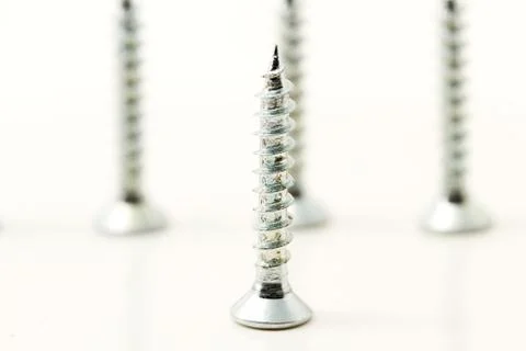 One screw in front of three Stock Photos