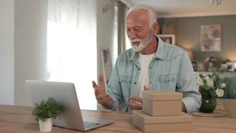One senior man open box presents and read card while on video call Stock Footage 250208540