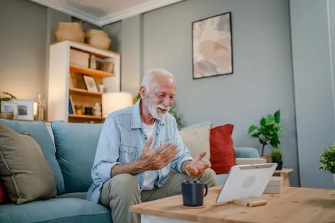 One senior man open box presents and read card while on video call Stock Photos
