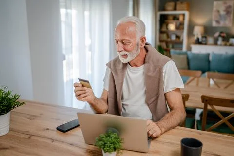 One senior man use laptop computer hold credit car shopping online Stock Photos