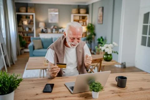 One senior man use laptop computer hold credit car shopping online Stock Photos
