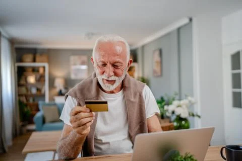 One senior man use laptop computer hold credit car shopping online Stock Photos