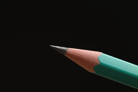 One sharp graphite pencil on black background, closeup. Space for text Foto stock