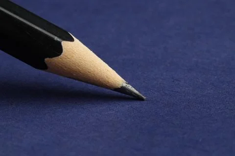 One sharp graphite pencil on blue background, closeup. Space for text Stock Photos