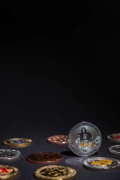 One Shiny Bitcoin close up, centered with other bitcoins lied on the desk. Stock Photos