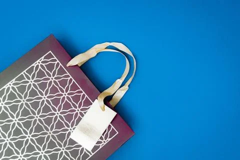 One shopping bag with Arabic pattern on blue background. Stock Photos