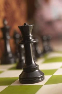 One side light on Black queen chess piece. close up photo Stock Photos