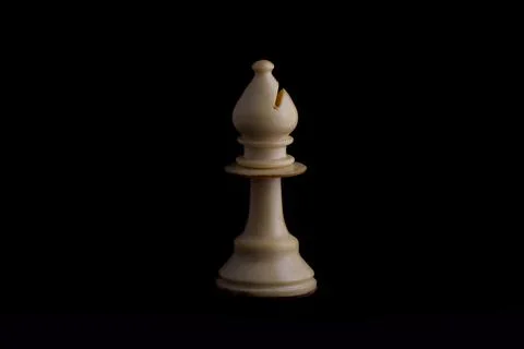 One side light on white bishop chess piece in black background Stock Photos