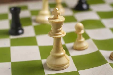 One side light on white king chess piece. close up photo Stock Photos
