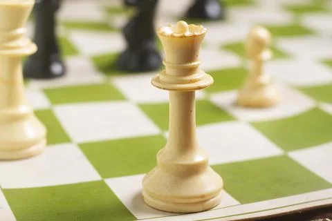 One side light on white queen chess piece. close up photo Foto stock