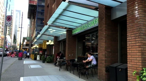 One side of Starbucks coffee on sunny day in downtown Vancouver Stock Footage 63749367