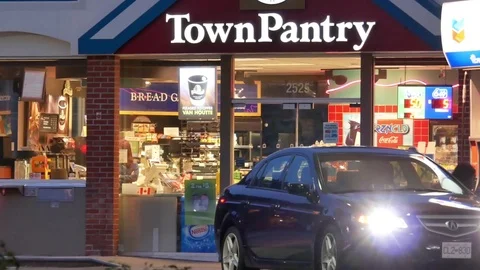 One side of townpantry convenience store beside Chervon gas station at night. Stock Footage 79915611