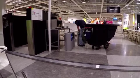 One side of worker cleaning garbage inside Ikea store Video stock 54479094
