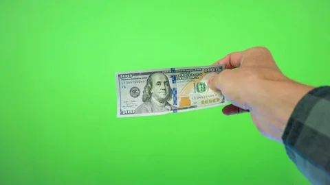 One silver bitcoin and US dollar in a man hands. Isolated on green background Stock Footage 84084022