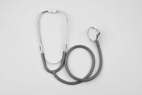 One single normal stethoscope isolated on top of a white color paper backgrou Stock Photos