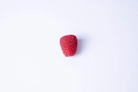 One single raspberry lies on a table Stock Photos