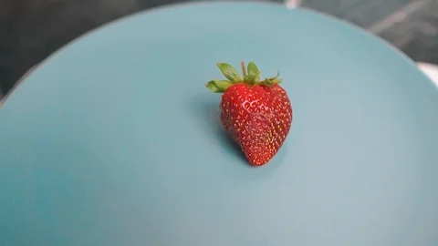 One single red strawberry rotating on grey background 動画素材 107731712