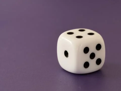 One single white dice lying on the table Stock Photos
