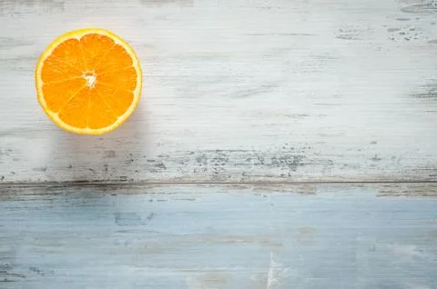 One slice of fresh oranges on painted wooden board Foto stock