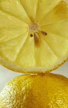One slice of lemon fruit on the lemon peel at vertical close up Stock Photos