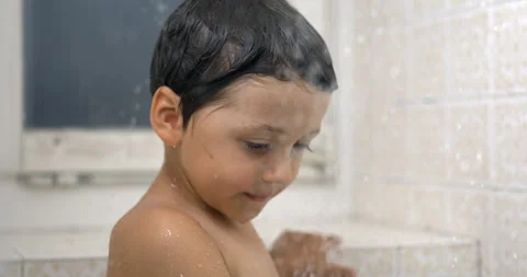 One small boy observing water droplets fall in super slow-motion standing i.. Видео 250236433