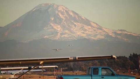 One small plane lands as the other takes off with Mt. Rainier in the background. Stock-Footage 139019363