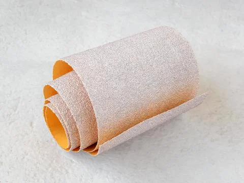 One small roll of extra coarse aluminum oxide sandpaper on a white. Stock Photos