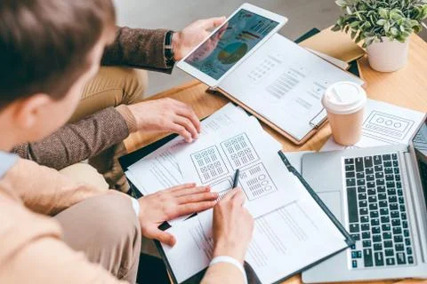 One of software developers explaining his colleague advantages of new program Stock Photos