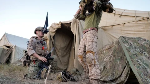 One soldier sets up the night-vision device, the other wears a bulletproof vest Stock Footage 128824298