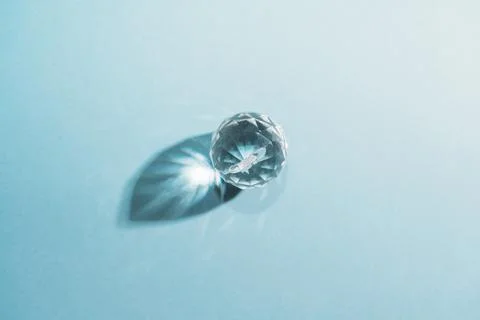 One sphere crystals with light refraction on blue minimal background Stock Photos