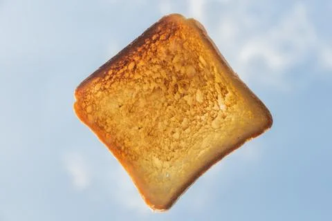 One square ruddy pieces of bread for toast on the blue sky with white clouds Foto stock