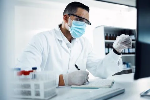 One step away from saving the day. a young scientist using a computer while 스톡 사진