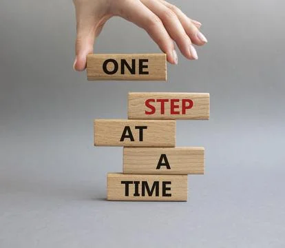 One step at a time symbol. Concept words One step at a time on wooden block.. Foto stock