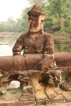 One of the stone giants lined up on the bridge leading to the Prasat Preah Kh Foto stock