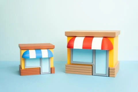 One store is larger than another showing business competition. Comparing fr.. Stock Photos