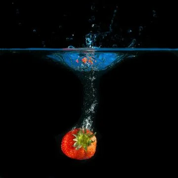 One strawberry splashing Stock Photos