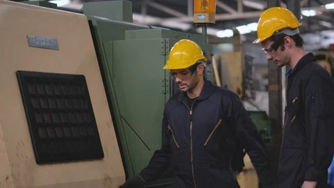 One technician or worker explain how to operate big machine to his co-worker Stock Footage 127826840