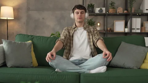 One teen man doing guided meditation yoga self care practice at home 스톡 동영상 264672332