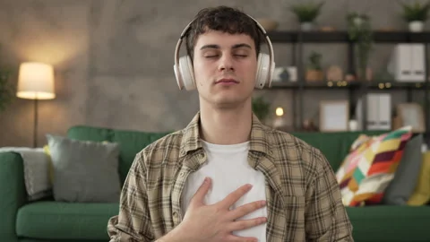 One teen man doing guided meditation yoga self care practice at home Stock Footage 264674794