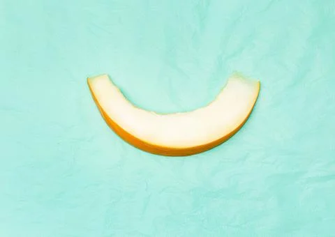 One thin slice of melon on a turquoise background. Foto stock