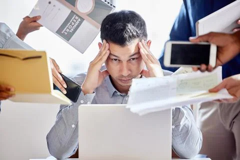 One thing at a time please. a young businessman looking stressed out in a Stock Photos