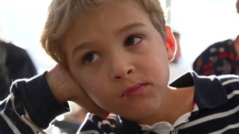 One thoughtful small boy eating cookie. Pensive kid taking a bite of snack... Stock Footage 229264259