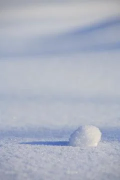 One tiny snowball on pristine snow surface at Winter, Finland 스톡 사진