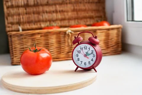 One tomato and red clock Stock Photos