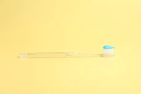 One toothbrush with toothpaste on yellow background Stock Photos