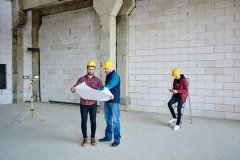 One of two engineers pointing at sketch on blueprint and specifying details Stock Photos
