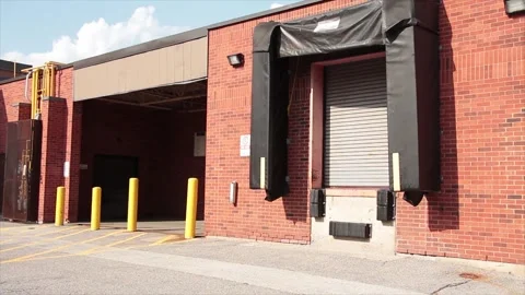 One two receiving bay garage doors next to each other in bright sun in summer Stock Footage 249754846