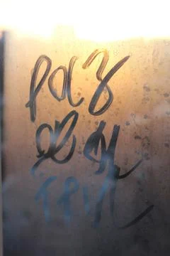 "one two three" written in Russian on a fogged window under the light of sunset Stock Photos