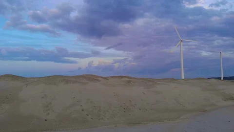 One of two wind turbines not functioning on purple sea sunset Video stock 130155266